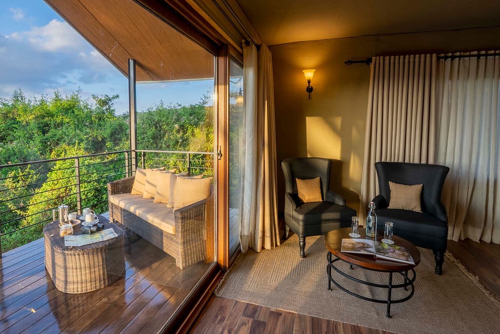 A private veranda with wicker seating and a coffee tray, opening off a lamplit room